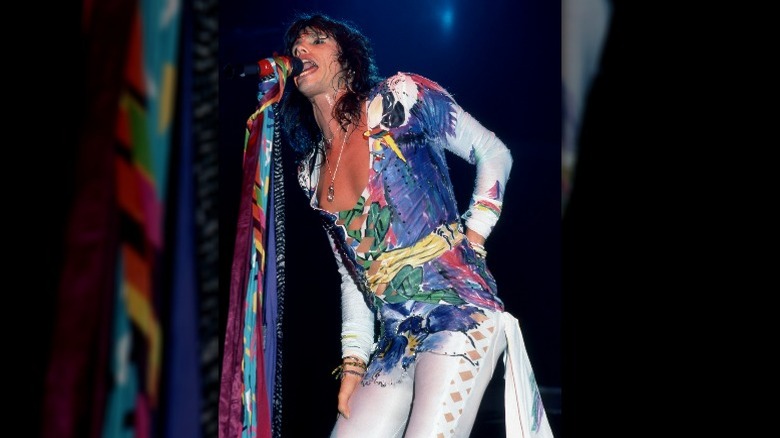 Steven Tyler performing in a multicolored jumpsuit 80s
