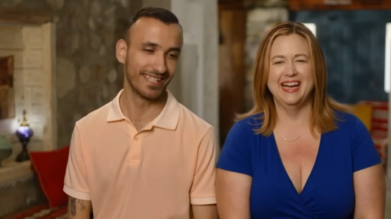 Laura Nevenner and Birkan Kuzoren laughing during a confessional on "90 Day Fiancé: Before the 90 Days"