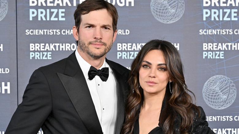 Ashton Kutcher posing with Mila Kunis
