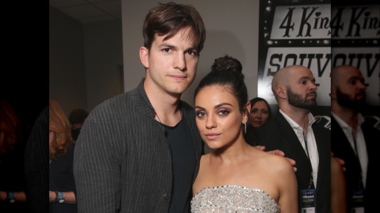 Ashton Kutcher posing with Mila Kunis
