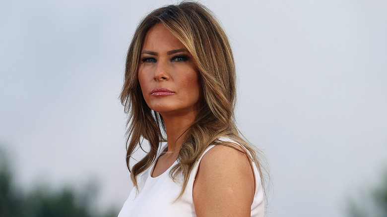Melania Trump white dress frowning