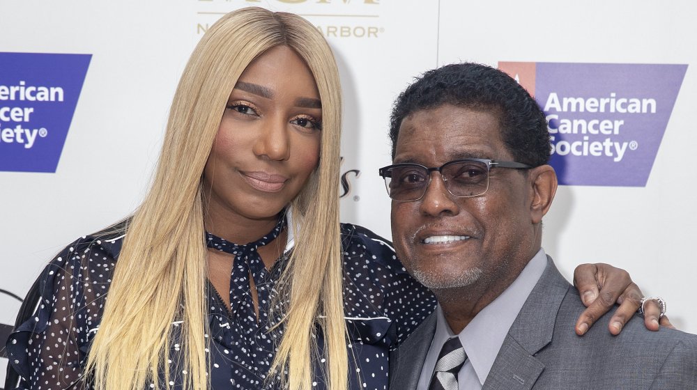 NeNe Leakes in a black-and-white polka-dotted top, Gregg Leakes in a gray suit, both smiling at an American Cancer Society event