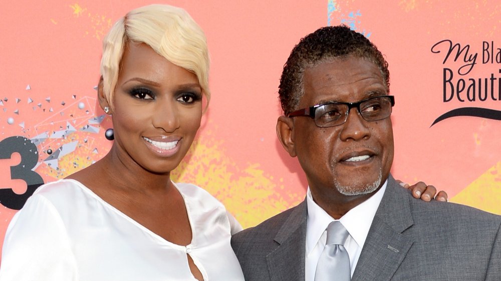 NeNe Leakes in a white dress, Gregg Leakes in a gray suit