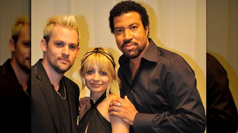 Joel Madden, Nicole Richie, and Lionel Richie posing together, all wearing black