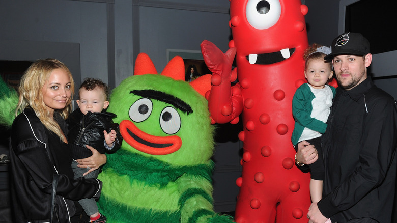 Nicole Richie and Joel Madden holding their kids at a Yo Gabba Gabba! event in 2010