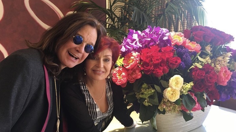 Ozzy and Sharon Osbourne posing with a bouquet of flowers at their vow renewal ceremony