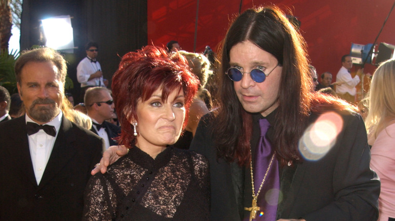 Sharon Osbourne frowning with Ozzy Osbourne on red carpet