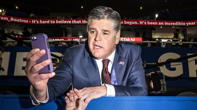 Sean Hannity holds a phone
