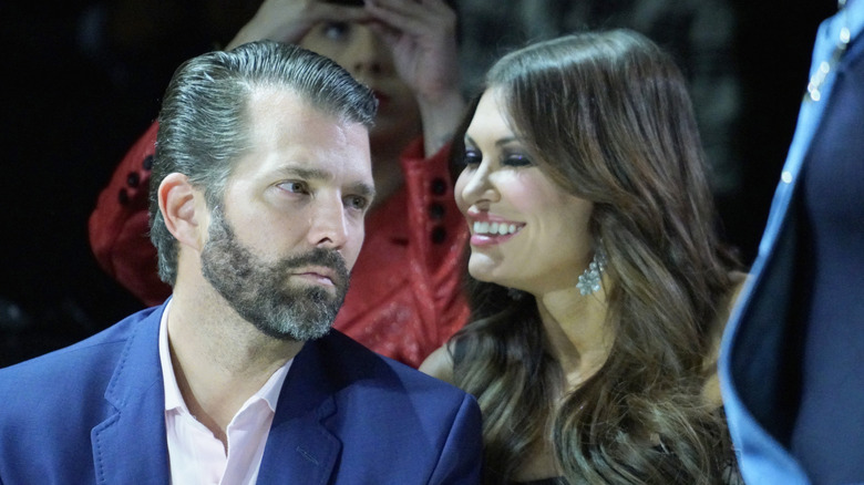 Donald Trump Jr staring to the side as Kimberly Guilfoyle laughs