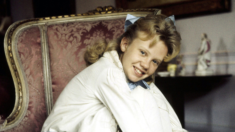 Hayley Mills wearing blue ribbon posing on chair