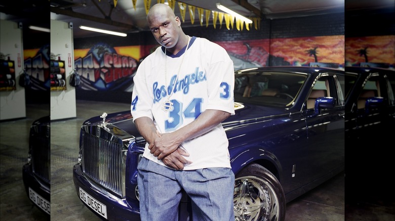 Shaquille O'Neal sits on the hood of a Rolls Royce