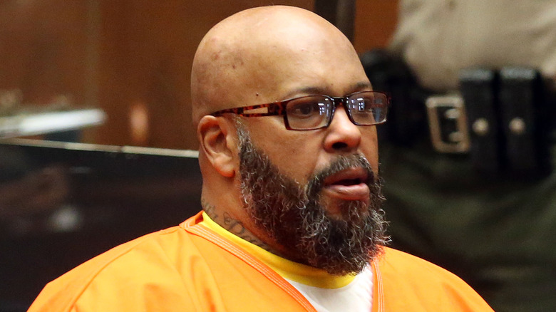 Suge Knight sitting in court wearing orange prison uniform