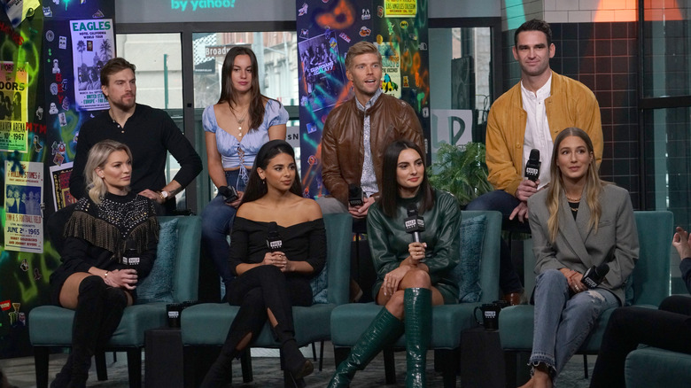 Season 5 cast members of "Summer House" sitting on a couch in 2020 with microphones