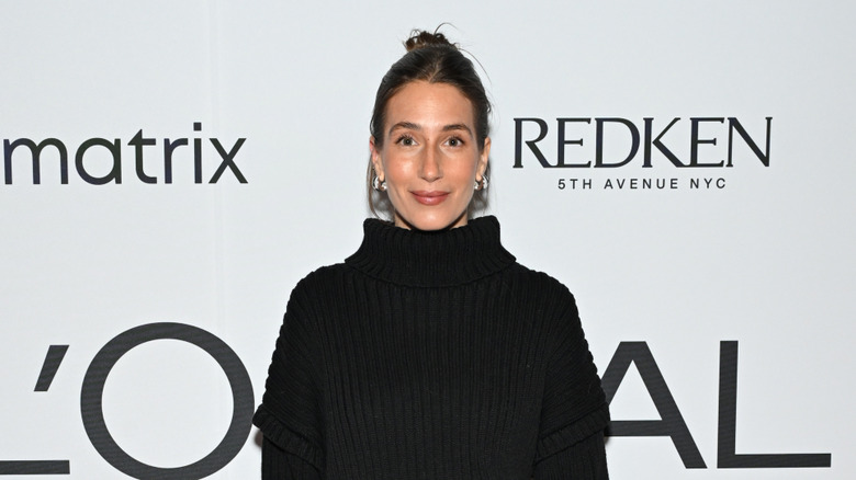 Amanda Batula with dark hair in a bun on the red carpet