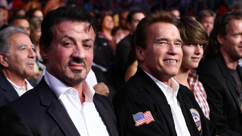 Sylvester Stallone and Arnold Schwarzenegger smiling