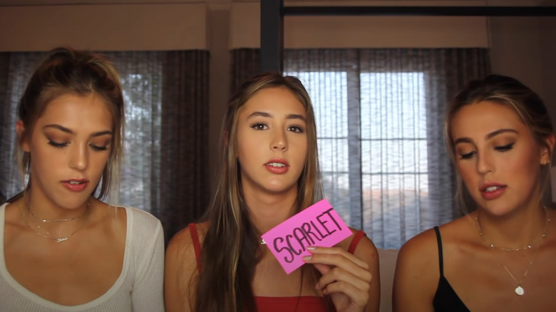 Scarlet Stallone holding paper with name on it next to her sisters