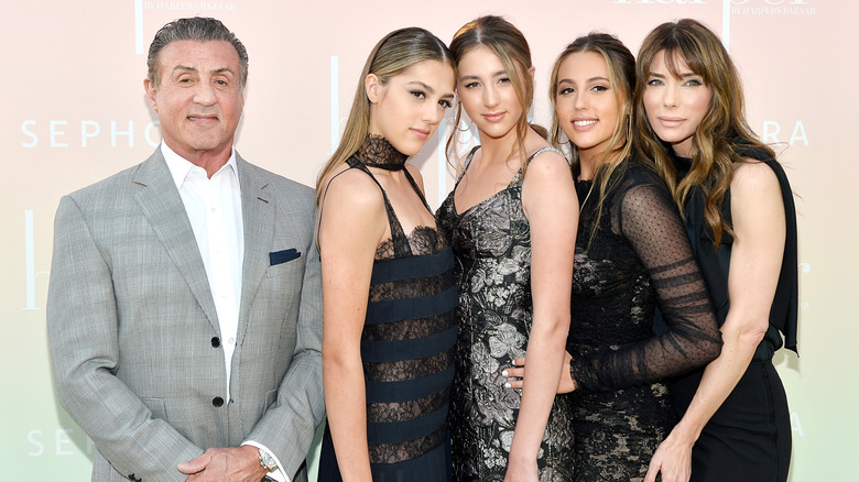 Sylvester Stallone posing with his wife and daughters