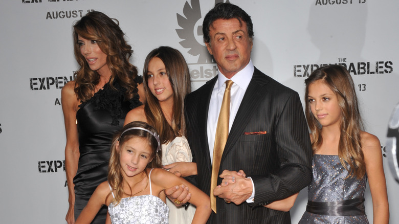 Sylvester Stallone posing with his wife and daughters