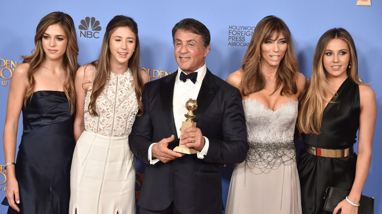 Sylvester Stallone posing with his wife and daughters