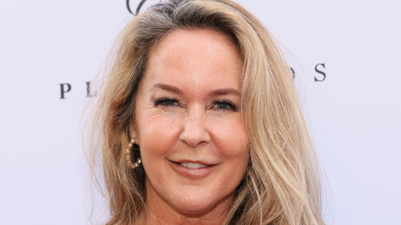 Erin Murphy smiling while posing at an event in a green dress