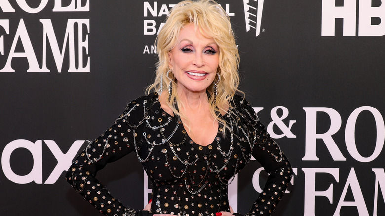Dolly Parton on the red carpet wearing black dress with studs