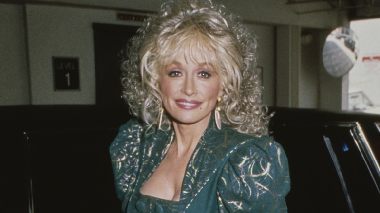 Dolly Parton wears a green dress backstage in the 1980s