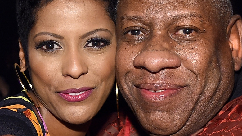 Tamron Hall touching cheeks with Andre leon talley and smiling 