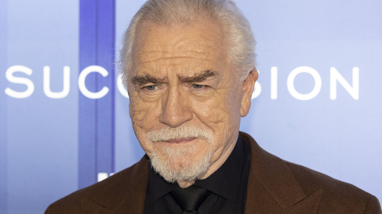 Brian Cox wearing a brown suit