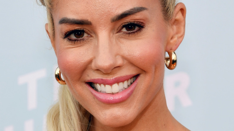 Heather Rae Young smiles in gold hoop earrings