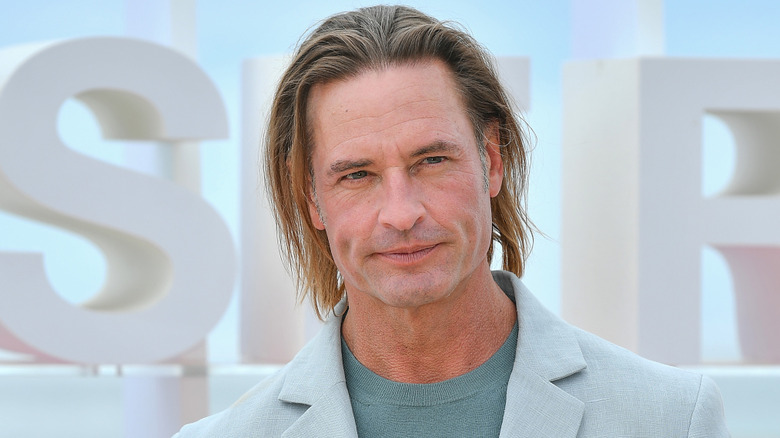 Josh Holloway posing in light-colored suit jacket at event