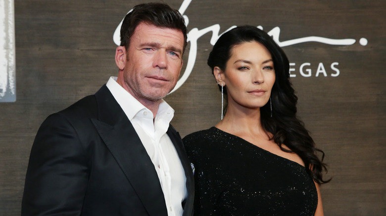 Taylor Sheridan and Nicole Muirbrook posing in all black at a premiere in 2021.