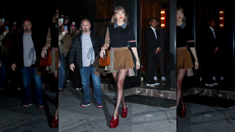 Taylor Swift smiling in high platform boots and a skirt