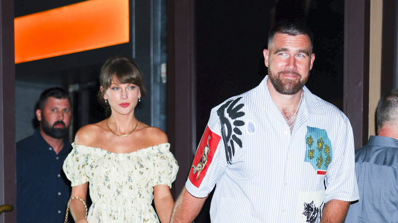 Taylor Swift and Travis Kelce walking together while holding hands