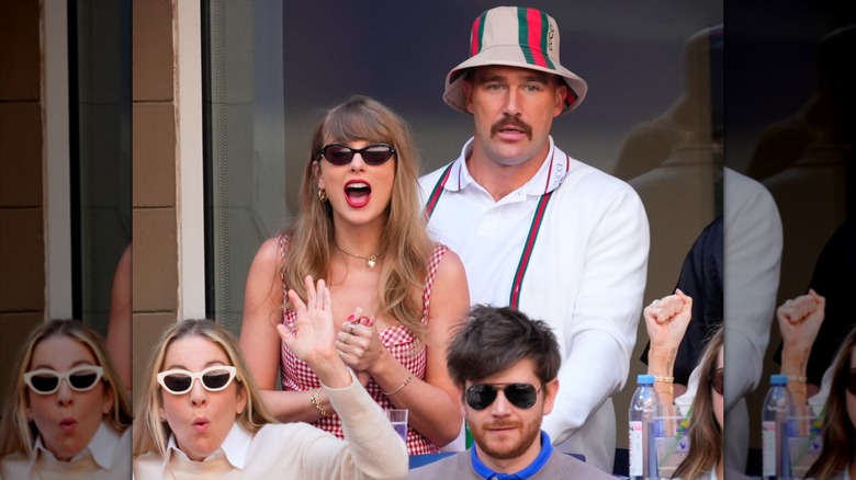 Taylor Swift wearing a gingham dress and Travis Kelce wearing a bucket hat at the Men's Final at the 2024 US Open Tennis Championships.