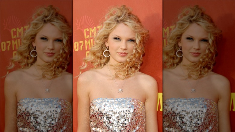 Young Taylor Swift posing at an event in a sparkly strapless dress