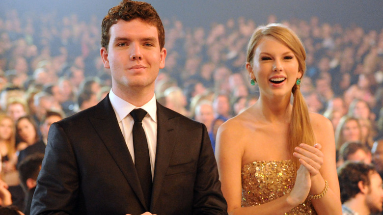 Austin Swift and Taylor Swift standing together