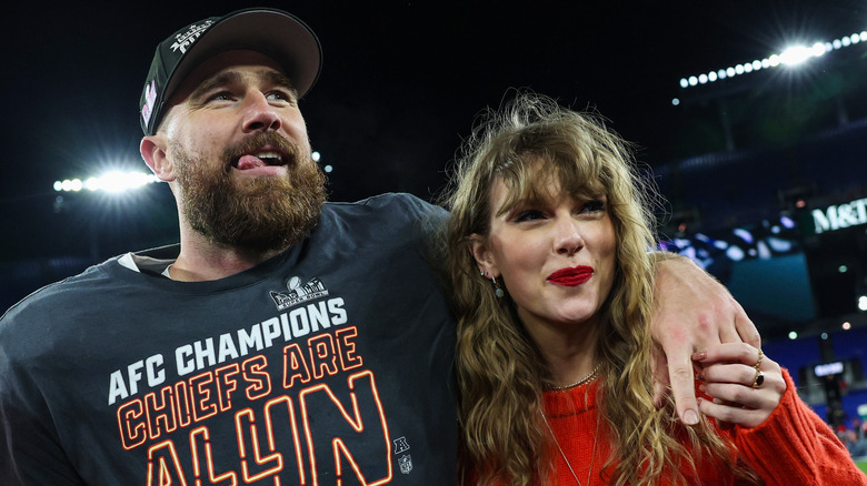 Travis Kelce and Taylor Swift pose together on the field