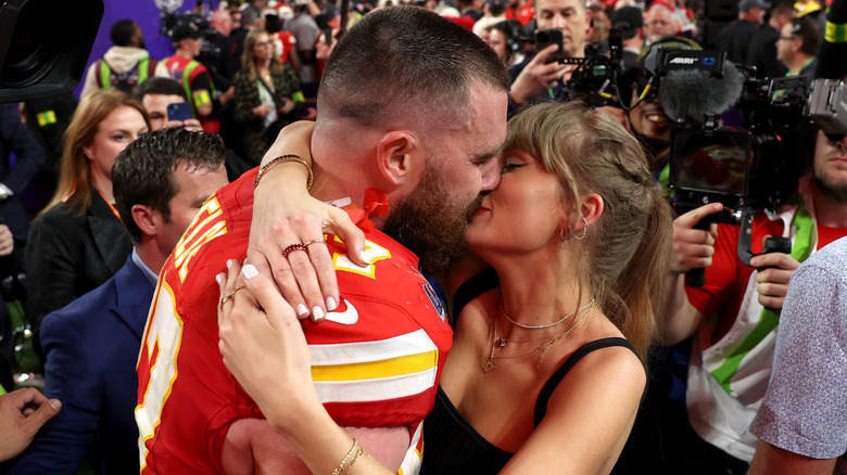 Taylor Swift and Travis Kelce kissing on the field
