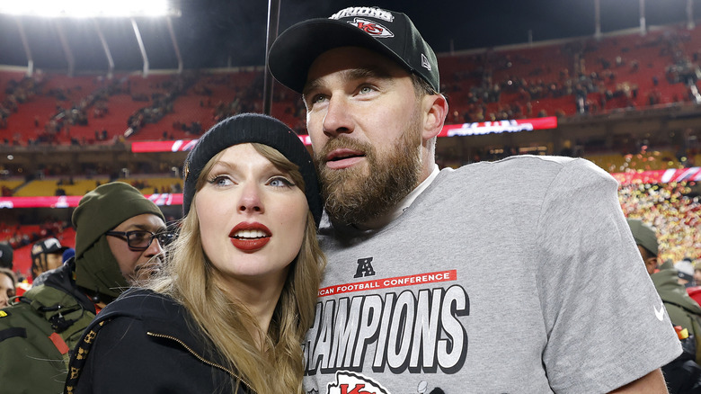 Travis Kelce embracing Taylor Swift on the field