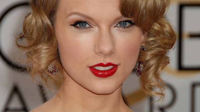 Taylor Swift smiling and wearing red lipstick