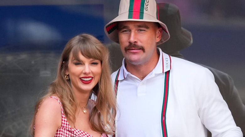 Travis Kelce and Taylor Swift together closely as they watch an event