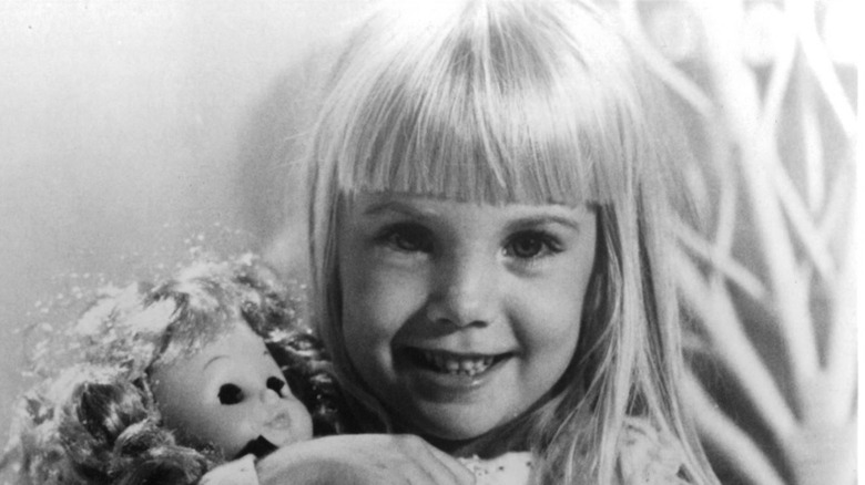 Heather O'Rourke smiling and holding doll