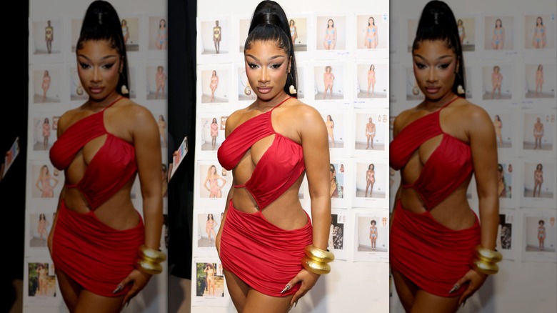 Megan Thee Stallion in a red dress at a swimwear fashion show.