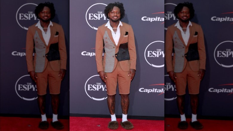Funny Marco wearing bear claw slippers, shorts, and patchwork blazer
