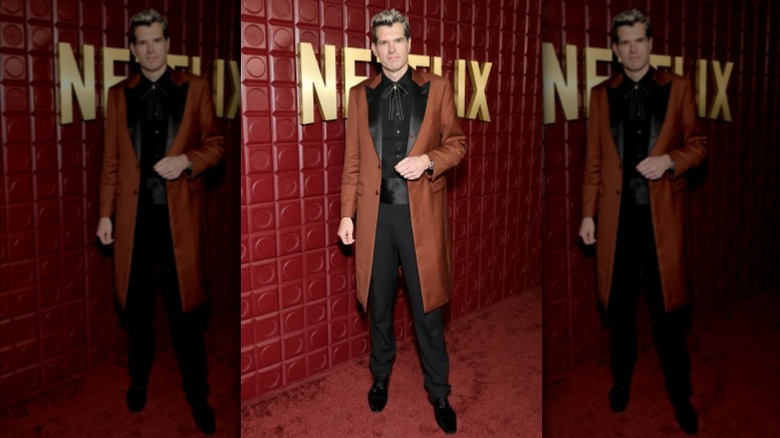 Timothy Simons wearing a brown coat, black shirt, and black pants