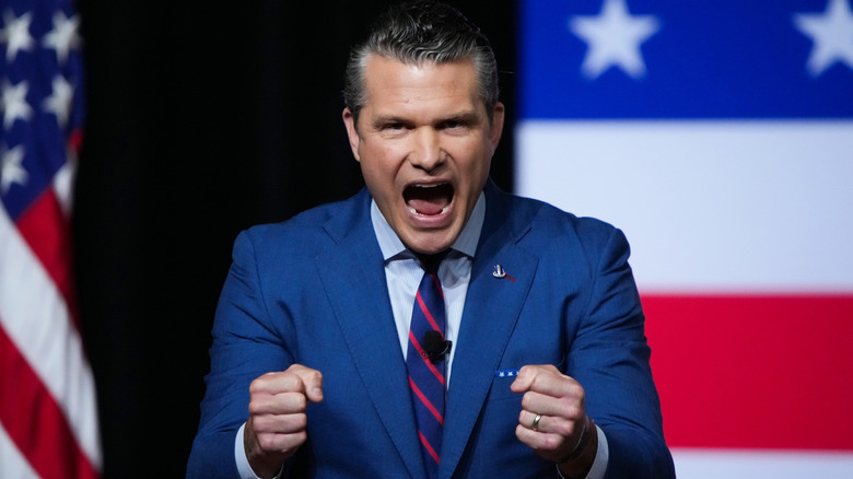 Pete Hegseth gestures animatedly on stage.