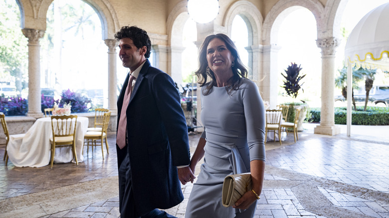 Sarah Huckabee Sanders smiling, holding hands with husband
