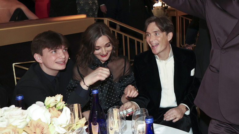 Aran Murphy sits at a table with Yvonne McGuiness and Cillian Murphy in 2024.