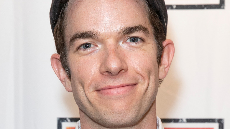 John Mulaney smiles at an  event