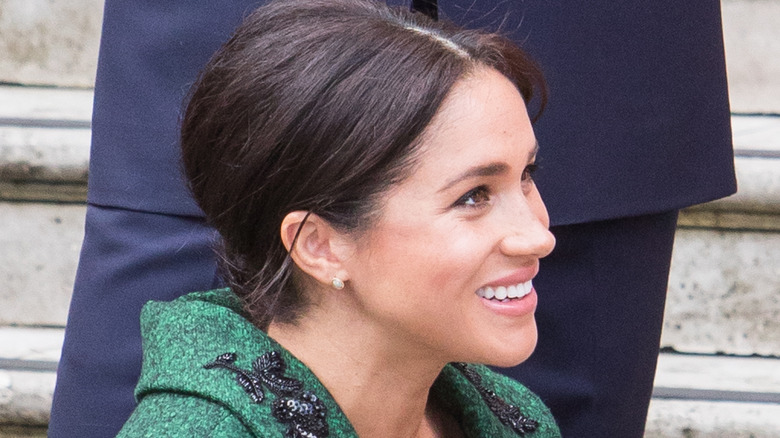 Meghan Markle bends down smiles